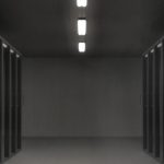 Sala de servidores com racks de equipamentos e iluminação colorida