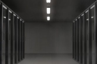 Sala de servidores com racks de equipamentos e iluminação colorida